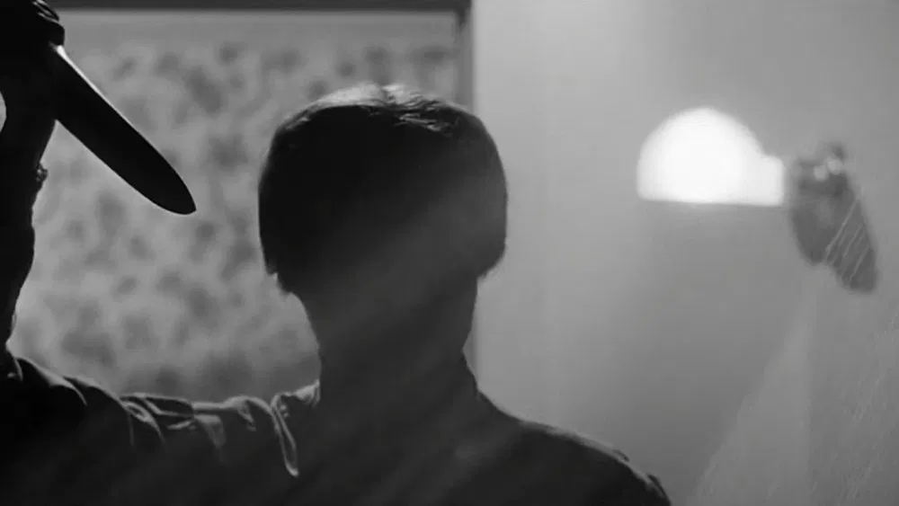 image of norman bates dressed as his mother with a knife in the 1960 movie psycho